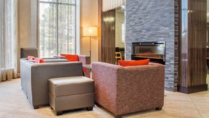 A modern living room with two sofas, a fireplace, and large windows. - Comfort Inn Burlington (Burlington)