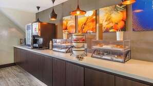 A modern kitchen area with a coffee machine, fruit bowls, and a microwave. - Comfort Inn Burlington (Burlington)