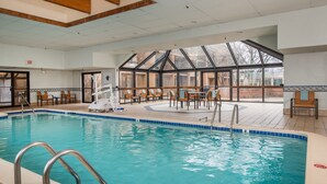 A swimming pool with a clear view of the surrounding area, including seating arrangements and a view of the outdoors through large windows. - Courtyard Fairfax Fair Oaks (Fairfax)
