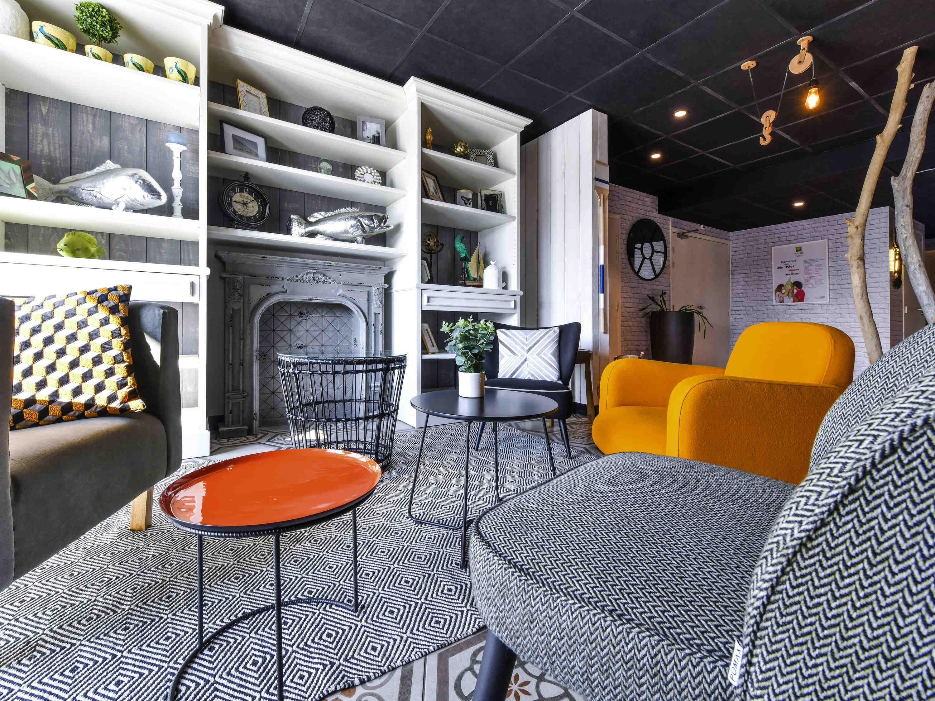 A modern living room with a fireplace, a sofa, a coffee table, and a bookshelf.