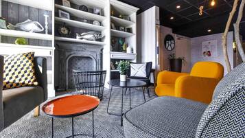 A modern living room with a fireplace, a sofa, a coffee table, and a bookshelf.
