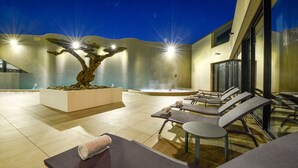 An outdoor relaxation area with a large tree, lounge chairs, and a hot tub. - Ibis Styles La Rochelle Thalasso Châtelaillon (Chatelaillon-Plage)