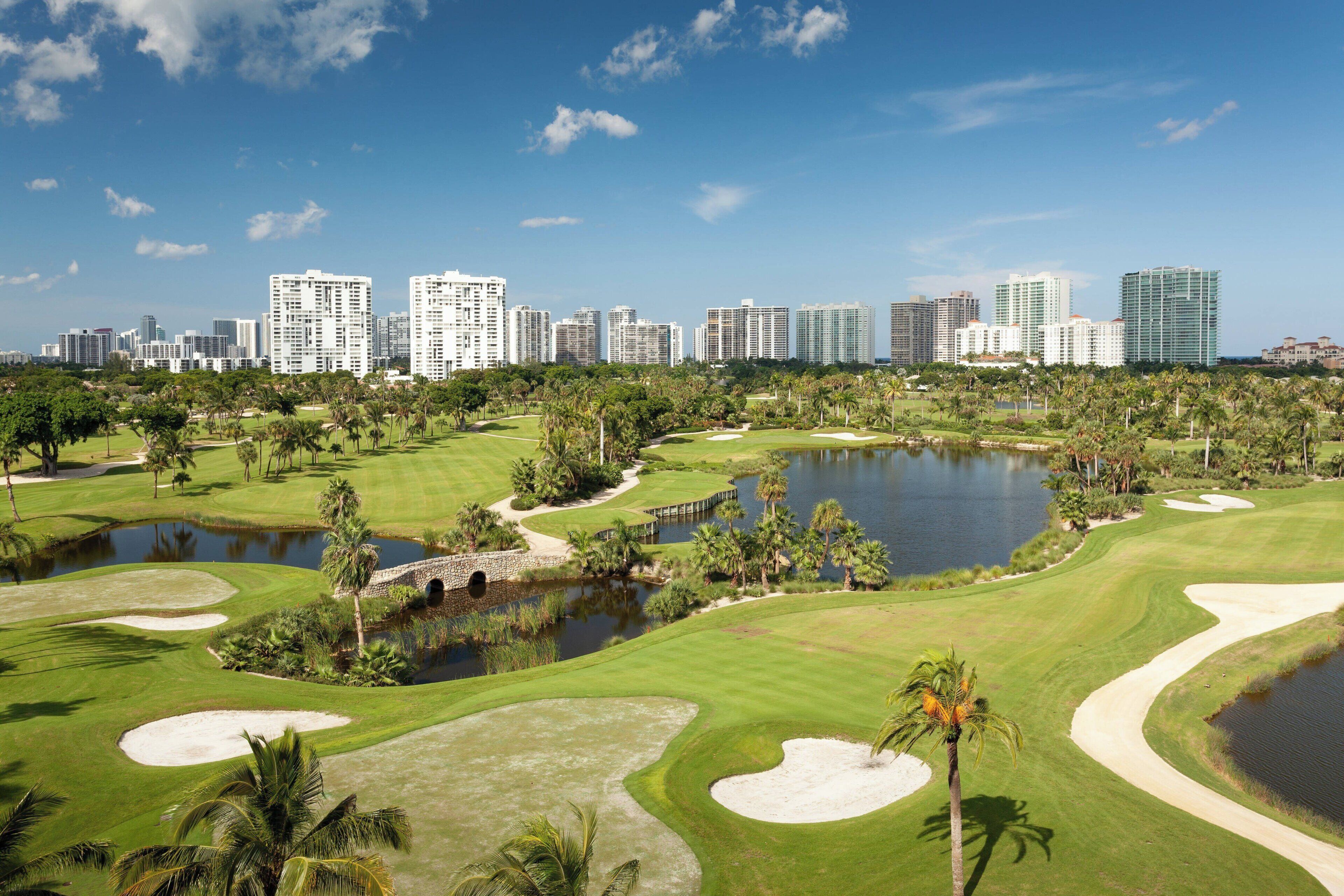 Un parcours de golf avec la silhouette de la ville en arrière-plan.