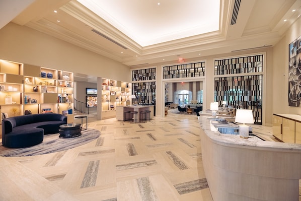 A spacious lobby with a reception desk, seating area, and a large bookshelf. - JW Marriott Turnberry Resort & Spa (Aventura)