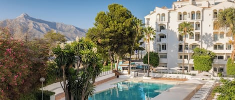 Una piscina al aire libre de temporada, sombrillas, tumbonas