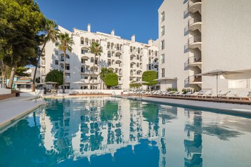 Una piscina al aire libre de temporada, sombrillas, tumbonas