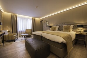 A modern hotel room with a large bed, a desk, a chair, and a small table. - Hotel Acacia (Bruges)