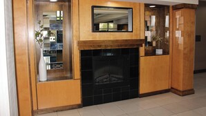Un intérieur moderne agrémenté d’une cheminée, de lambris en bois et d’un miroir placé au-dessus.