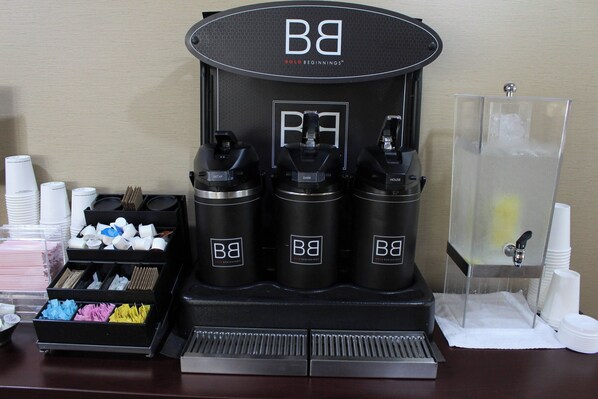A coffee station with three dispensers labeled 'BB' and a water dispenser.