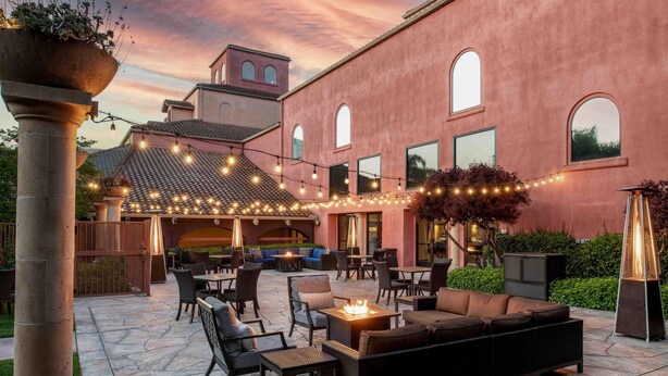 An outdoor patio area with seating arrangements, string lights, and a fire feature. - DoubleTree by Hilton Sonoma - Wine Country (Rohnert Park)