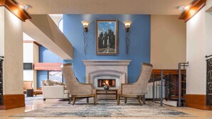 A lobby with a fireplace, two armchairs, a sofa, and a large rug. - DoubleTree by Hilton Sonoma - Wine Country (Rohnert Park)