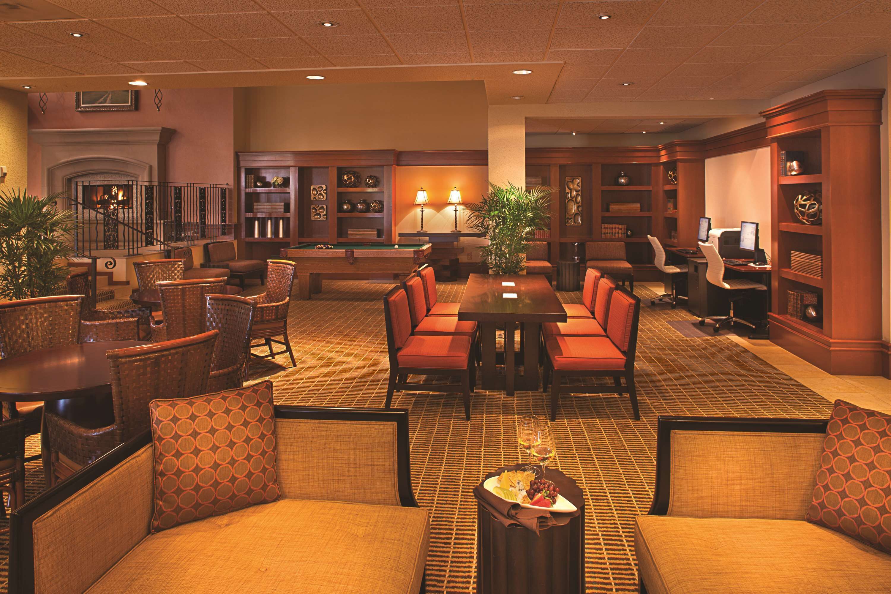 Un hall d’entrée spacieux avec une table de billard, des sièges confortables et une cheminée.