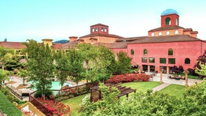 A hotel with a pool, lush gardens, and a red building with a blue dome. - DoubleTree by Hilton Sonoma - Wine Country (Rohnert Park)