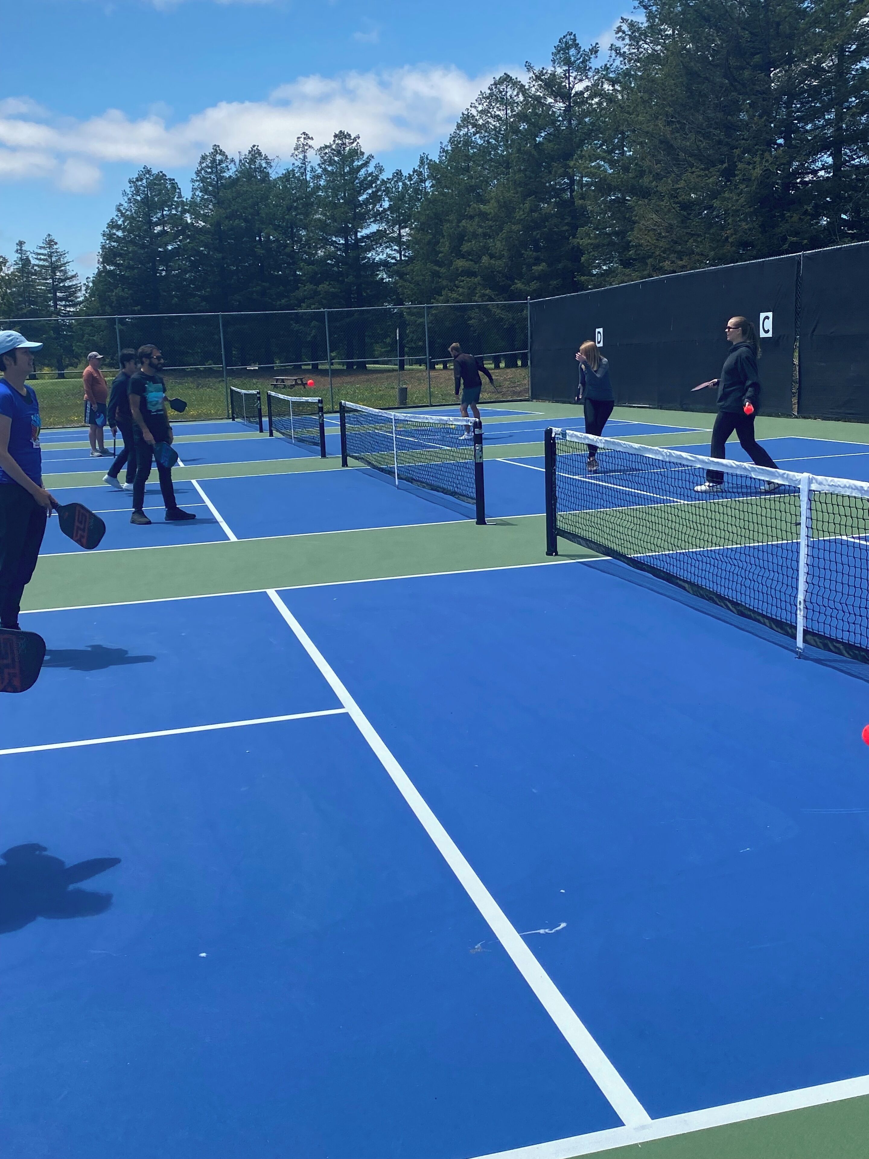 A tennis court with multiple players and a net.