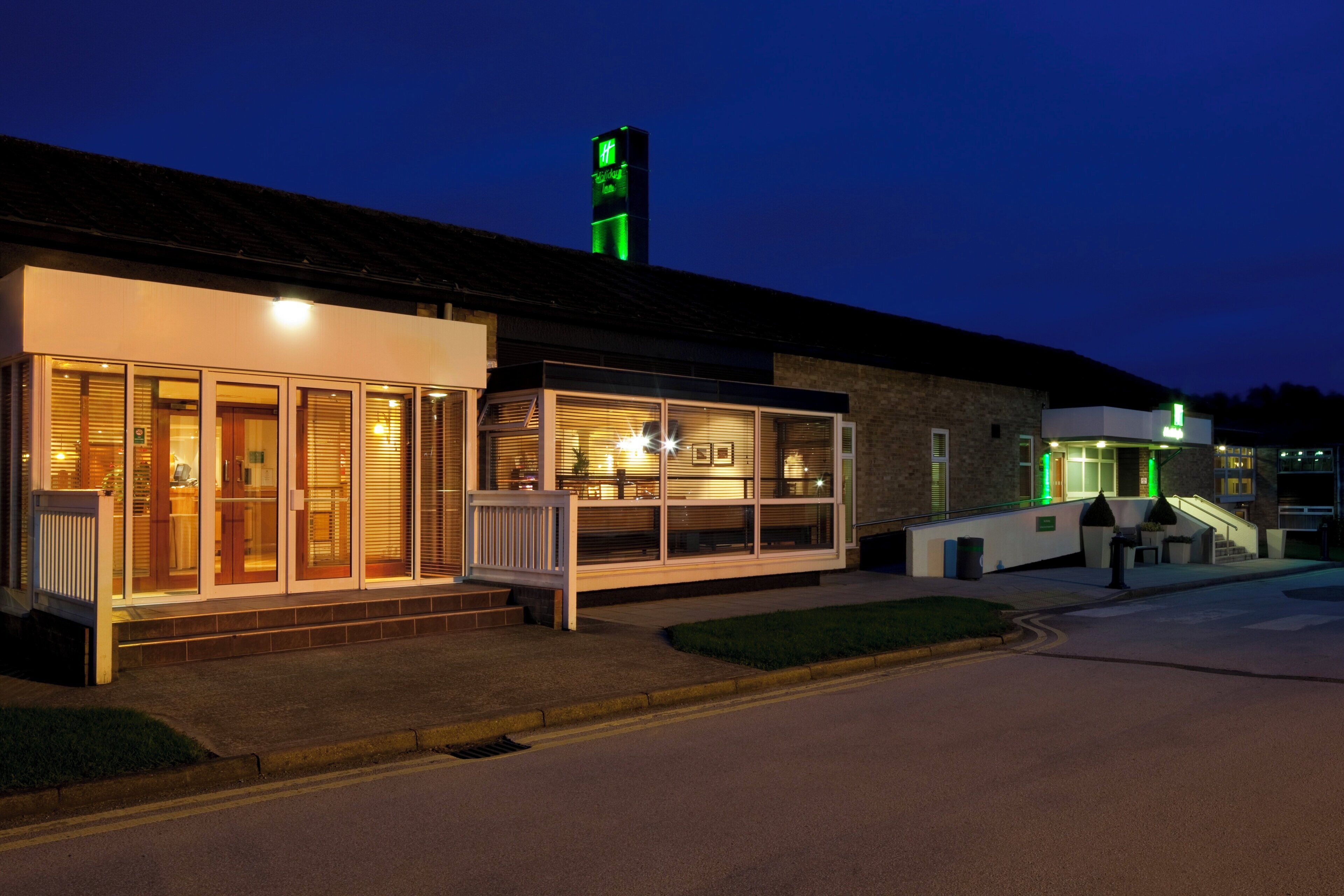 A building with a storefront, a staircase, and a green-lit tower.