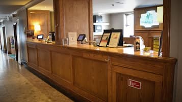 Un mostrador de recepción con detalles de madera, una pantalla digital y un cartel que indica Holiday Inn.