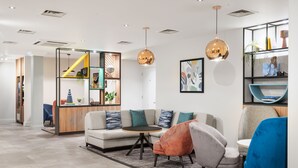 A modern living room with a sofa, chairs, a coffee table, and pendant lights. - Holiday Inn Derby Nottingham M1 J25 by IHG (Nottingham)