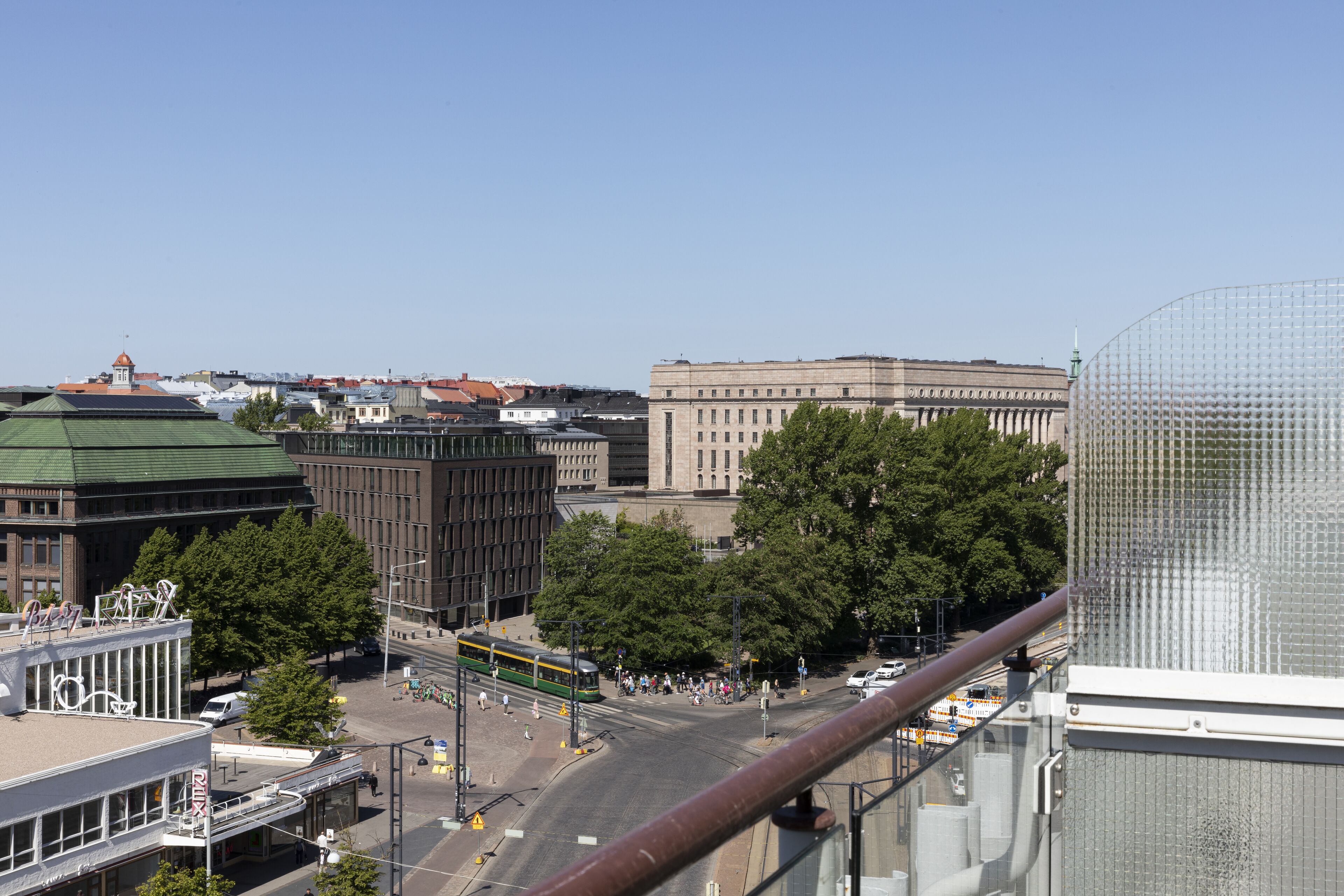 A cityscape with a tram, buildings, and a clear sky.