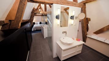Une salle de bain moderne avec un lavabo blanc, un miroir et un porte-serviettes.