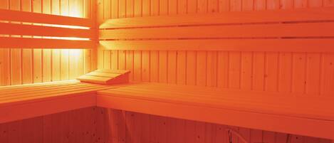A sauna with wooden benches and a bucket.