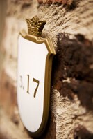 A house number plaque on a brick wall.
