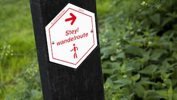 A sign with a red arrow and text indicating a walking route.