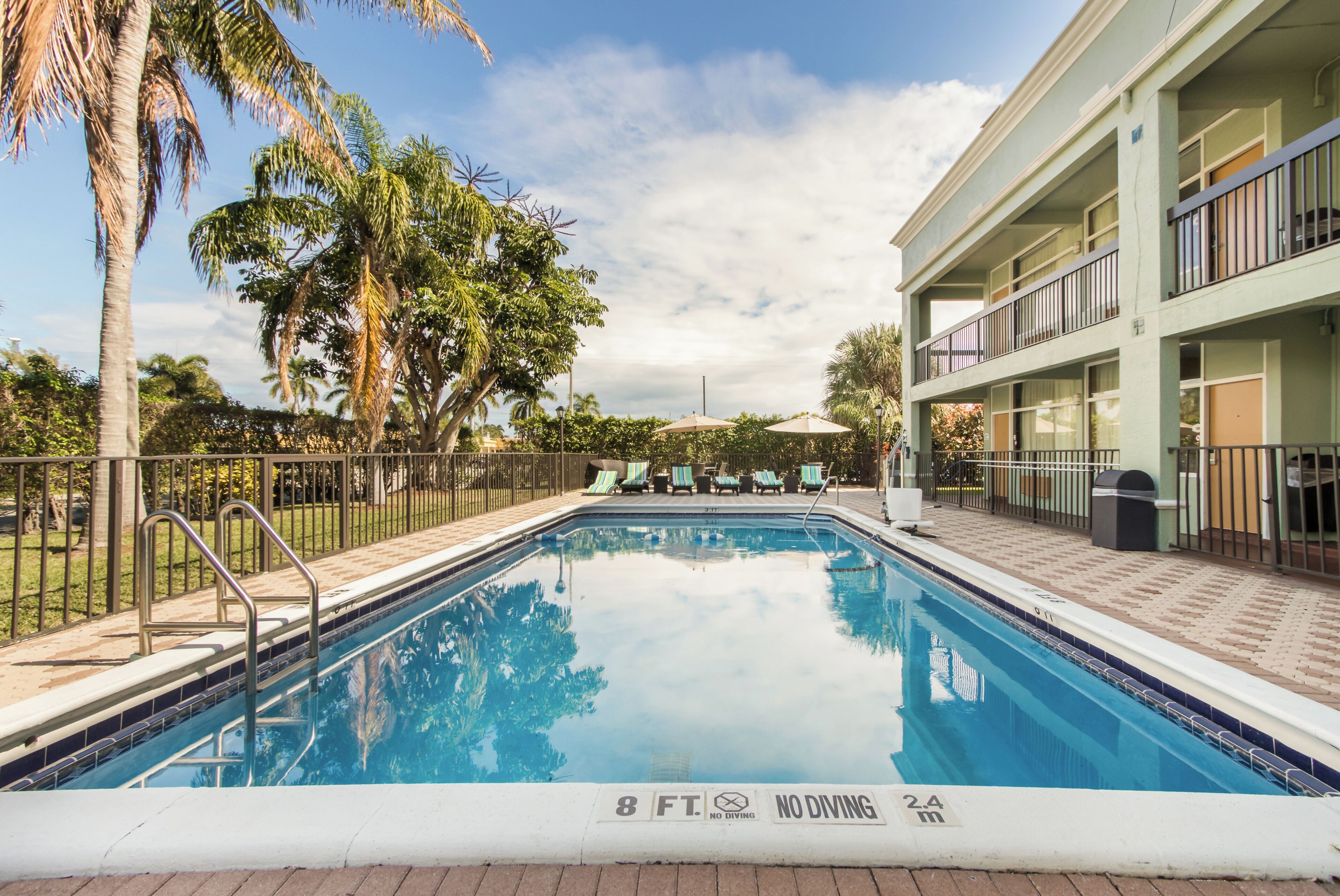 Alberca al aire libre, sombrillas en la alberca y camastros 