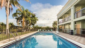 A swimming pool with a no diving sign, surrounded by palm trees and lounge chairs. - Boca By the Sea (Boca Raton)