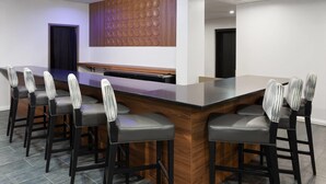 Uma sala de conferências com uma mesa comprida, seis cadeiras e uma parede de destaque em madeira.