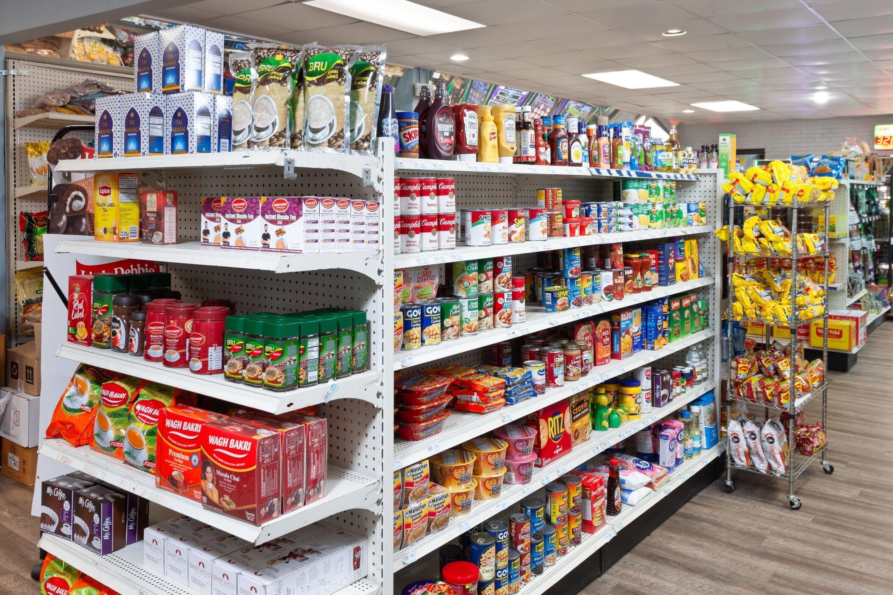 Un rayon d’épicerie où l’on trouve divers produits alimentaires et articles ménagers, présentés sur des étagères.