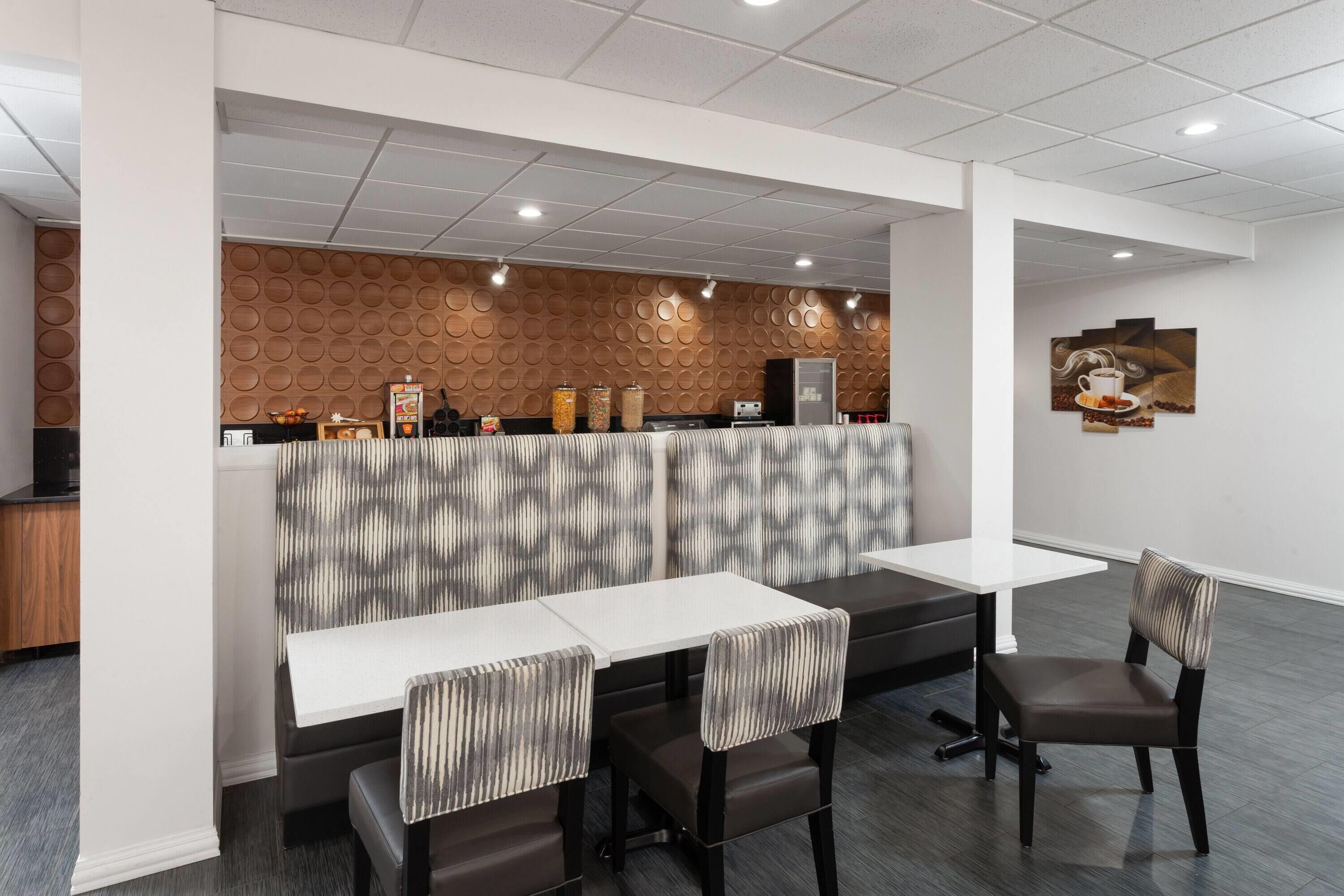 Un restaurante moderno con mostrador, zona de estar y una pared decorativa.