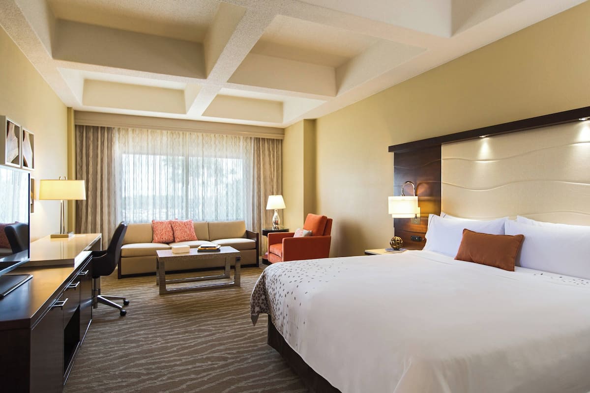 Een hotelkamer met een groot bed, een bank, een bureau en een stoel.