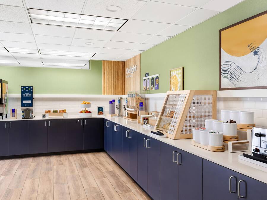 A modern kitchen with a central island, built-in appliances, and a variety of food items and condiments.