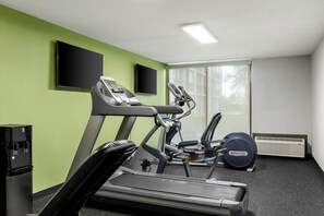 A gym with treadmills, an elliptical, and a water dispenser. - Spark by Hilton Akron Fairlawn (Akron)