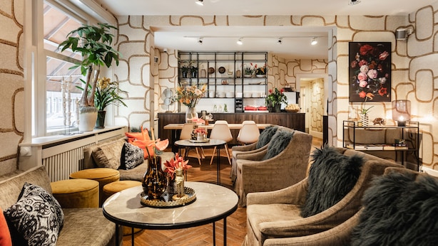A cozy lounge area with comfortable seating, a coffee table, and a decorative wall with a geometric pattern. - The Delphi - Amsterdam Townhouse (Amsterdam)
