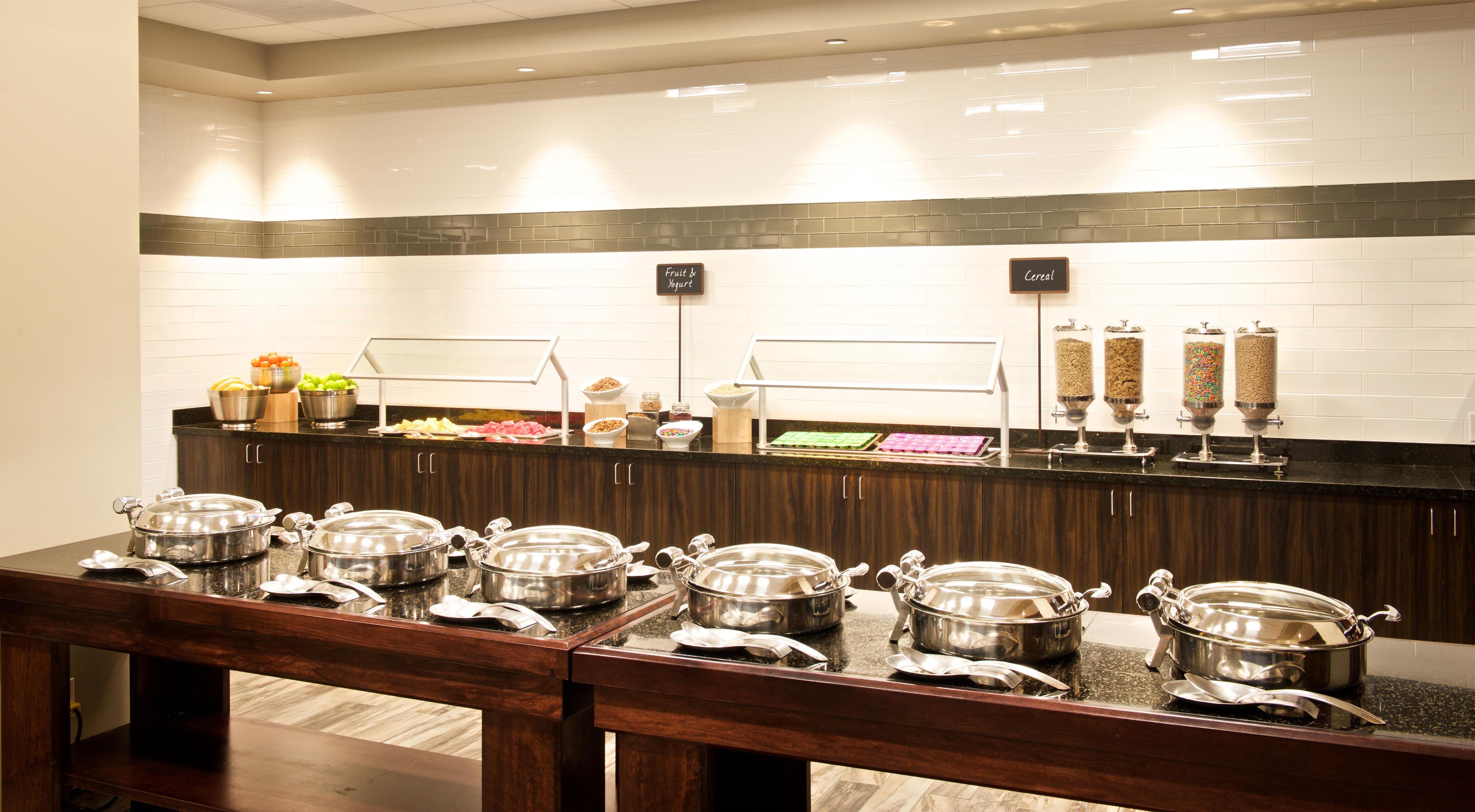A buffet setup with various food items and containers.