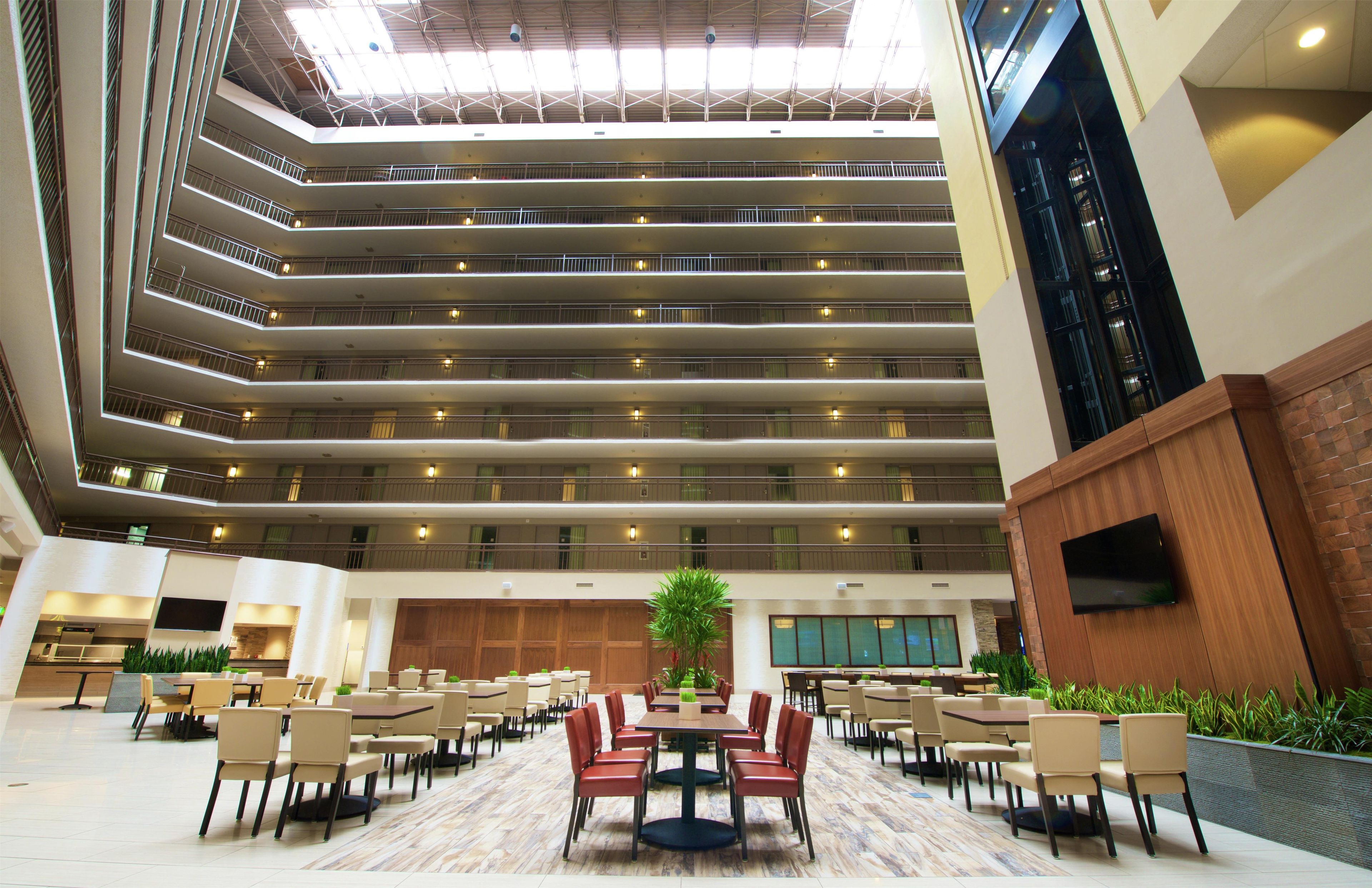 A multi-level atrium with a central open space, surrounded by dining areas with tables and chairs.