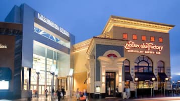 A building with a large sign reading "Washington Square" and another sign for "The Cheesecake Factory."