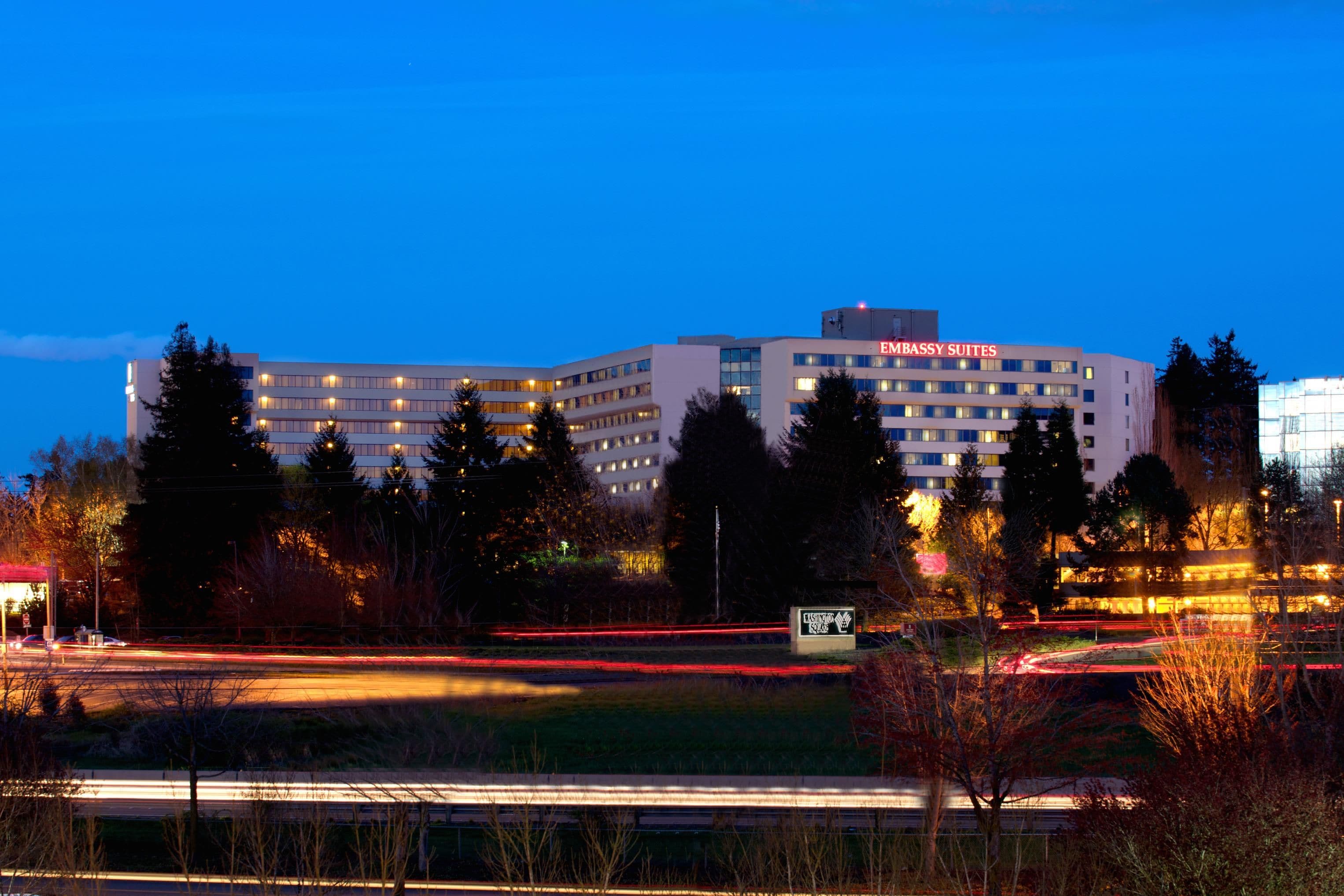 Un edificio de varios pisos con un letrero que dice 'EMBASSY SUITES' en la parte superior.
