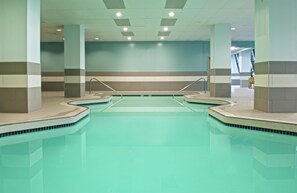 A large indoor swimming pool with multiple lanes, surrounded by tiled walls and columns. - Embassy Suites by Hilton Portland Tigard (Tigard)