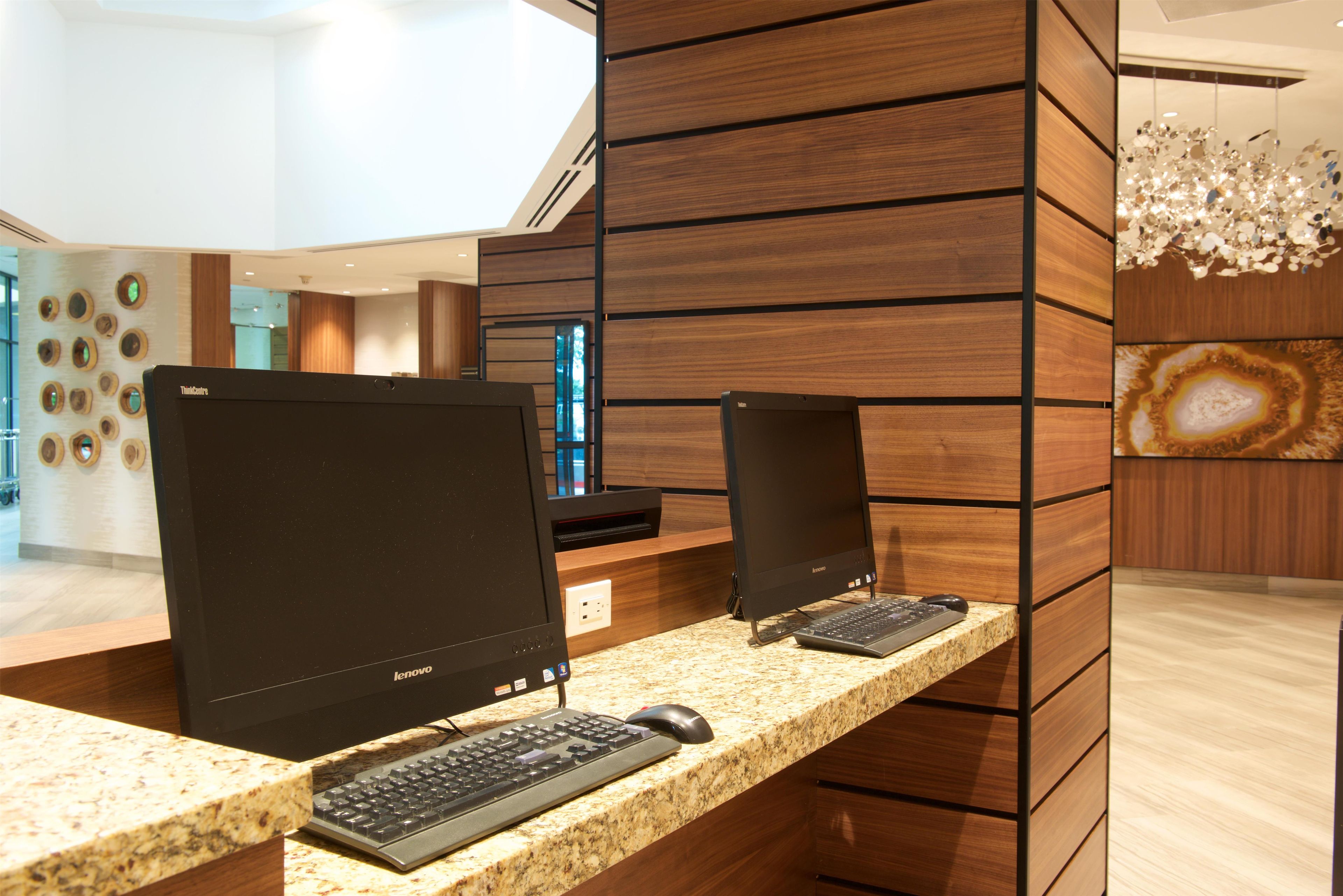 En receptionsdisk med to Lenovo-skærme, et tastatur og en mus.