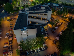 Vue aérienne d’un hôtel doté de plusieurs parkings et d’un grand bâtiment sur lequel on peut lire l’inscription « Embassy Suites ».