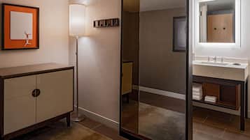 A modern bathroom with a large mirror, a vanity with a sink, and a cabinet.