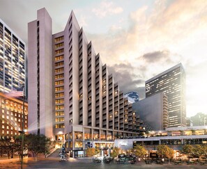 Een modern hotel met meerdere verdiepingen, een centrale binnenplaats met terraszitplaatsen en een opvallend restaurant op de begane grond.
