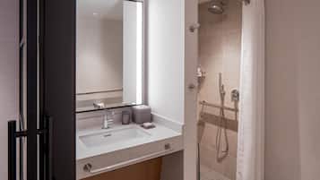 Un baño moderno con lavabo, espejo y ducha.