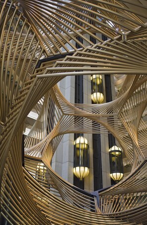 A spiral staircase with a geometric design, leading to an upper floor.
