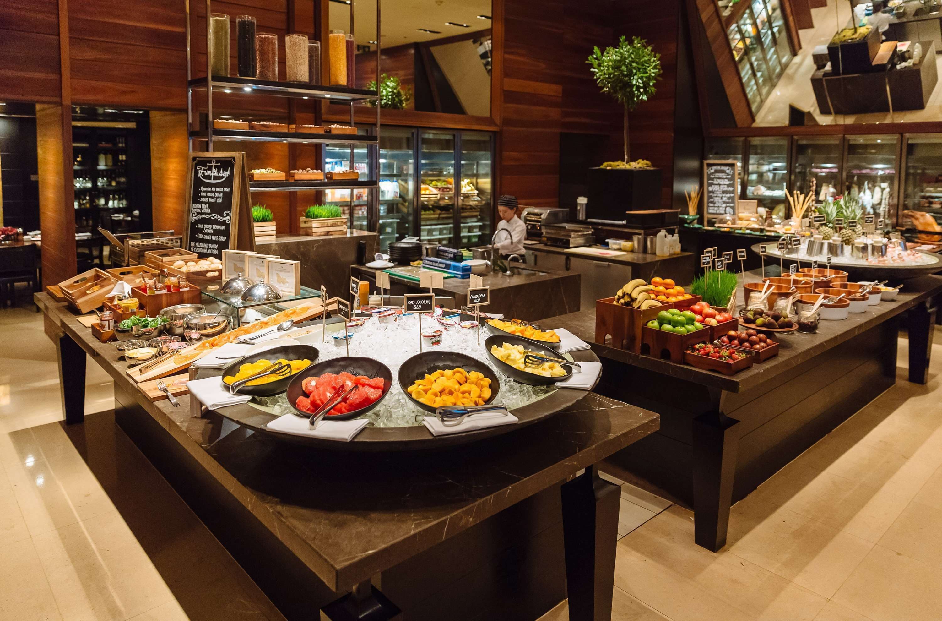 Un área de bufé con diversas opciones de comida y una estación de baristas.