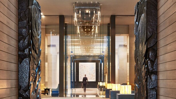 A modern lobby with a central staircase, glass walls, and a large chandelier. - Grand Hyatt Melbourne (Melbourne)