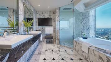 A modern bathroom with a large mirror, two sinks, a bathtub, and a glass-enclosed shower.