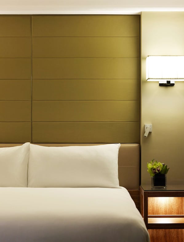 A hotel room with a large bed, a headboard, a bedside table with a lamp, and a small plant. - Grand Hyatt Melbourne (Melbourne)